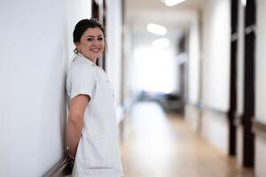 A tired nurse takes a quiet moment to rest in the hospital hallway, reflecting on a long and demanding shift. photo