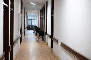 A row of wheelchairs neatly lined up in a hospital corridor, ready for patients in need of mobility assistance photo