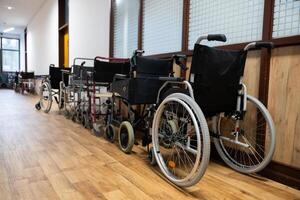 A row of wheelchairs neatly lined up in a hospital corridor, ready for patients in need of mobility assistance photo