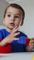 Baby boy learning colors and shapes playing with toys. Toddler studying through the game. Low angle view. Vertical video