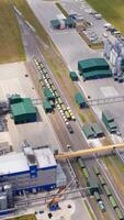 Contemporary agriculture complex. View from above on industry with large storage bins for keeping crop. Freight trains and grain elevators on field. Top view. Vertical video