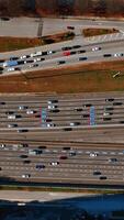Numerous cars and lorries move to both sides of the road. Top view on the speedway on daytime. Vertical video