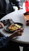a person sitting at a table with a plate of food nobleseed photo