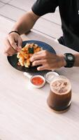 a person eating fries with a drink and a cup of coffee photo