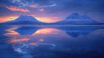 Snow-capped mountains mirrored in a serene, tranquil lake at sunrise. photo