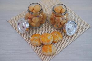 two small glass jars filled with golden brown bite sized cookies photo