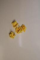Yellow scraps of paper are thrown on a white background. photo