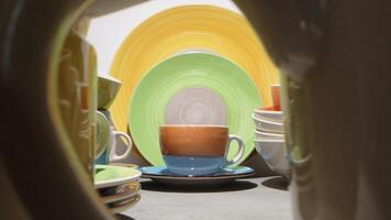 se av färgrik krukmakeri med en nyckfull kopp och tallrik skapande en vibrerande mittpunkten i en mysigt miljö video