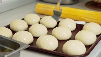 Baker prepares dough balls for baking at a local kitchen during the afternoon video