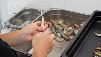 Preparing shrimp skewers in a kitchen for grilling with fresh ingredients video