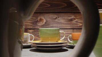 Cups and plates arranged on a wooden table showcasing vibrant colors and unique patterns video