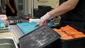 Chef skillfully preparing salmon fillets in a professional kitchen setting with precise knife techniques and fresh ingredients video