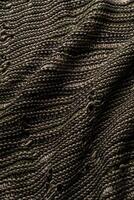 Detailed view of woven fabric showcasing a blend of dark and light threads, forming an intricate texture and ideal for use in textile design. photo