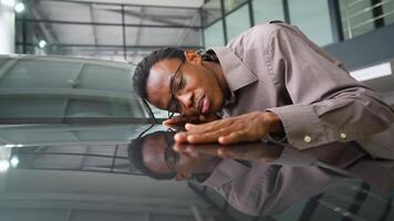 Man Admiring Reflection on Car Hood in Showroom video