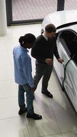 Car Salesman Showing SUV Features to Potential Buyer video