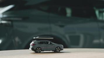 A small car model toy driving on a table against blurred auto background. Premium car buying experience that combines expert guidance with high-class service in an elegant setting video