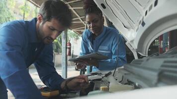 EV car check, mechanic workers coworker inspects and service of electric engine and battery in fixed automobile garage station, professional technology transportation industry business. video