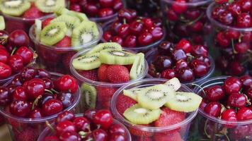 Fresh fruit display with cherries, strawberries and kiwi in cups video