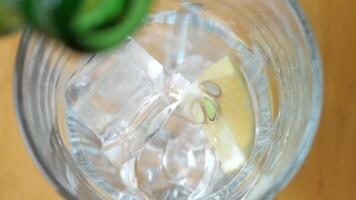 Refreshing drink with ice and lemon slice in clear glass video