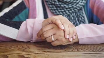 Elegant hands resting on a wooden table in a cozy setting video