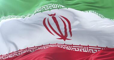 Flag of Iran waving at wind in slow in blue sky, loop video