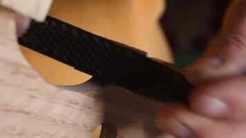 Luthier sanding a part of the structure of a new violin or viola video