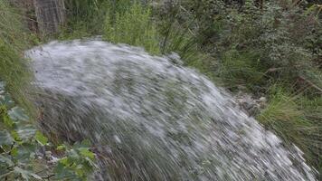 Stream of water emerging from a mountain rock spring video