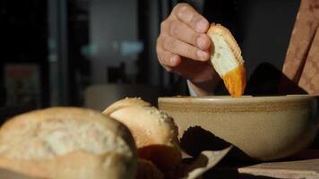 Enjoying fresh bread and dipping sauce at a cozy cafe setting video