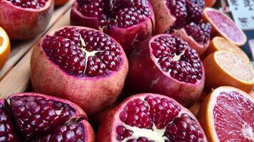 Fresh pomegranates and oranges displayed at local market stand video