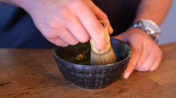 Preparing traditional matcha using a bamboo whisk in Japan video