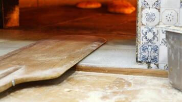 Baking bread in a traditional oven with wooden paddle and rustic tiles video