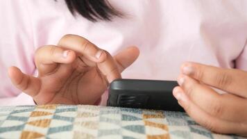 Child Engaging with a smartphone while relaxing on a cozy sofa video