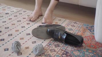 Shoe left by the couch with bare feet on the rug video