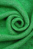 Close-up of a rolled green fabric texture for design and textile applications. photo