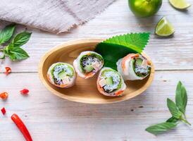 Shrimp and Sausage with Vietnamese Rice Paper Roll with lemon served in basket isolated on wooden background top view of Hong Kong food photo