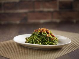 Sauteed Kang Kong with Sambal served in a dish isolated on mat side view on dark background photo