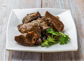 Braised Bovine Lung with savory sauce, sesame seeds and cilantro served in plate on Wood Table Close up Side view of Hong Kong food photo