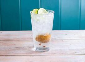 Salted Lemon and Lime Soda with ice cube served in glass isolated on wooden background side view of Hong Kong drink photo