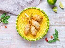 Vietnamese Grilled Shrimp on Sugarcane with lemon served in plate isolated on wooden background top view of Hong Kong food photo
