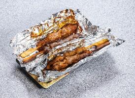 Charcoal Grilled Chicken Skewers served in tray dish isolated on stone background side view of Kong Asian street food photo