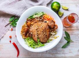 Lemongrass Chicken Wings with rice vermicelli noodles, fresh vegetables, and crushed peanuts served in plate isolated on wooden background top view of Hong Kong food photo