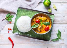 Thai chicken Red Curry with Rice with lemon served in plate isolated on wooden background top view of Hong Kong food photo