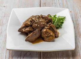 Braised Chicken Liver with savory sauce, sesame seeds and cilantro served in plate on Wood Table Close up Side view of Hong Kong food photo