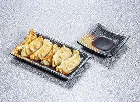 Moon Fried Dumplings Gyoza with dipping sauce served in tray dish isolated on stone background side view of Asian Dim Sum Hong Kong photo