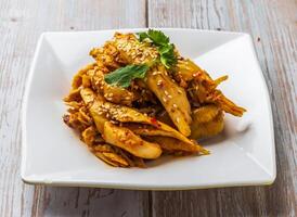 hot and spicy shredded chicken with savory sauce, sesame seeds and cilantro served in plate on Wood Table Close up Side view of Hong Kong food photo