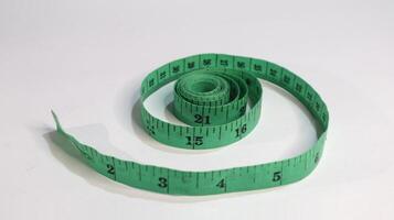 Green measuring tape isolated on white background photo