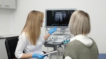 Female Doctor consulting a patient before Ultrasound, Sonogram Procedure. Sonography of internal organs. Hyperthyroidism, hypothyroidism, thyroid health checkup photo