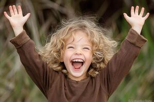 A young boy with his hands up in the air photo