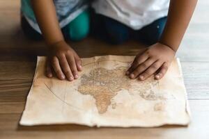 Two children are sitting on a wooden floor with a map photo