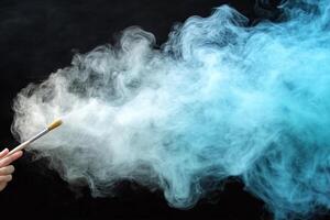 A person holding a paintbrush in front of a blue smoke cloud photo